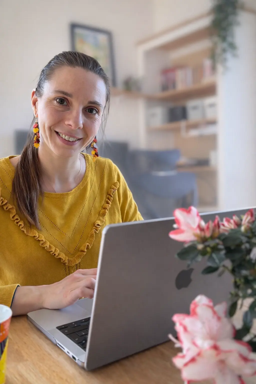Sabrina qui sourit, en travaillant sur son ordinateur pour Pyxelle