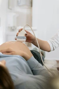 Sage-femme réalisant une échographie de grossesse en cabinet – création de site internet pour sage-femme